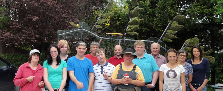 Die Gartenbaugruppe Stainach und Jugendliche von der Produktionsschule Liezen vor der Narzissenfest-Figur.